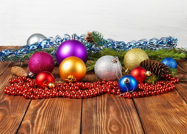 Des jouets et des cônes d'arbre de Noël colorés sont dispersés sur une table en bois Espace de copie