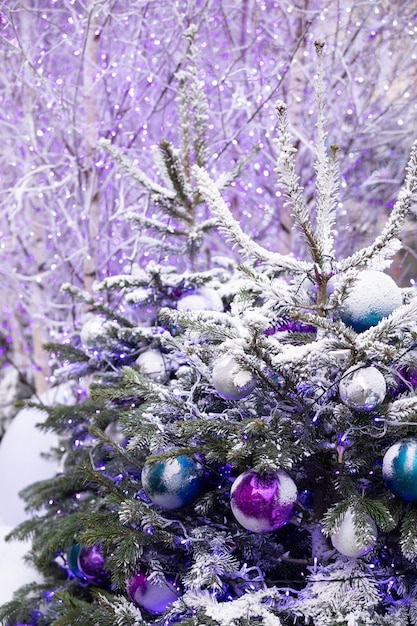Des jouets de décoration de Noël et des guirlandes lumineuses scintillent sur les branches d'un arbre de Noël