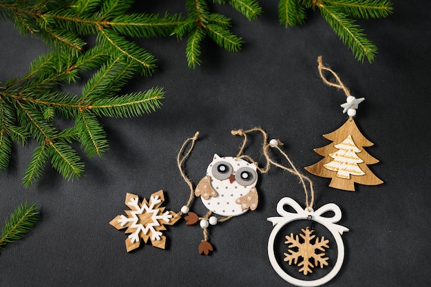 Jouets faits à la main en bois sur une table noire vide décorée de branches vertes dans le coin supérieur