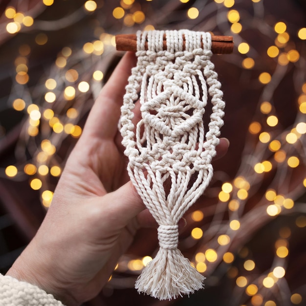 Jouets de macramé de Noël sur fond sombre Matériaux naturels fil de coton perles de bois et bâton Décorations écologiques ornements décor fait à la main Vacances d'hiver et du Nouvel An