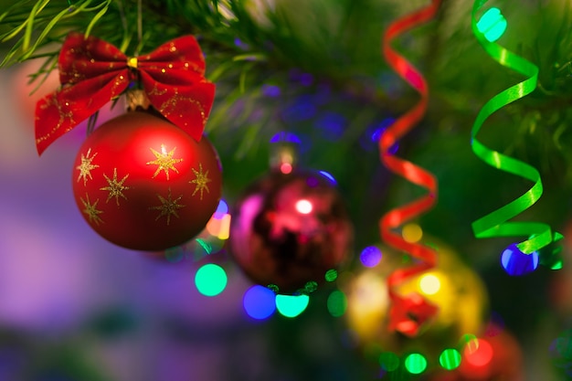 Jouets de Noël sur l'arbre de Noël avec éclairage. Boules vibrantes lumineuses sur fond lumineux flou et bokeh avec flou artistique. Joyeux Noel et bonne année.