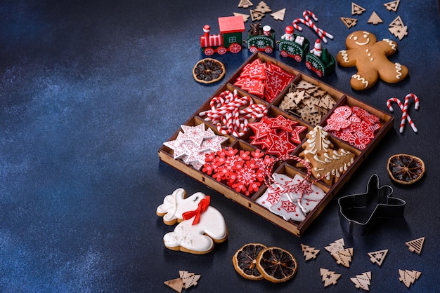 Jouets de Noël en blanc et rouge dans une boîte en bois sur un fond de béton foncé