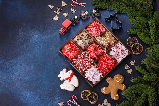 Jouets de Noël en blanc et rouge dans une boîte en bois sur un fond de béton foncé