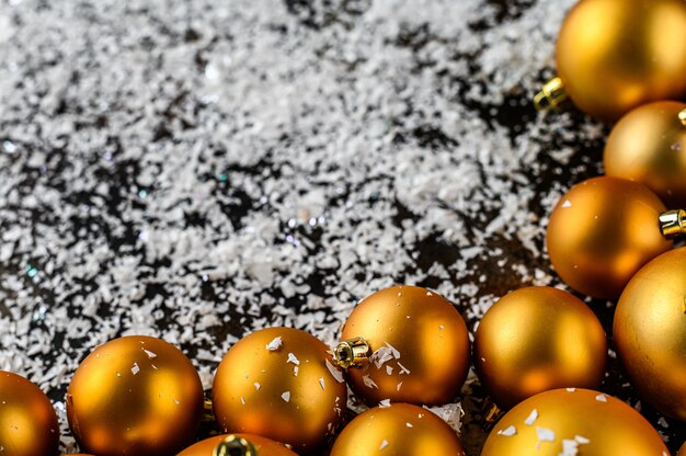 Jouets de Noël dorés avec fond blanc de flocons de neige