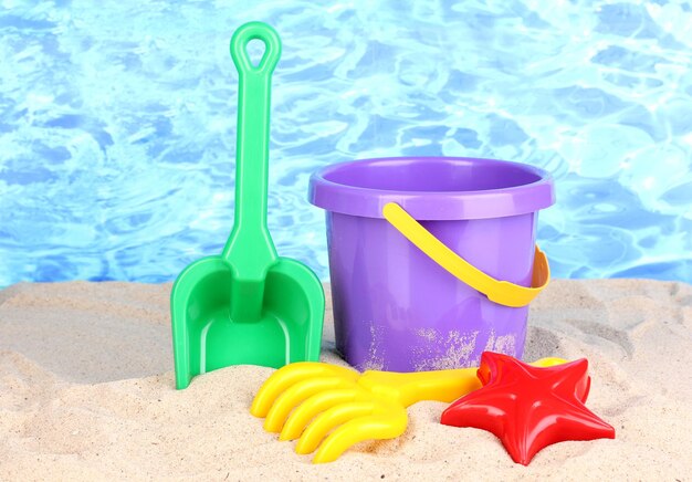 Jouets de plage pour enfants sur le sable sur fond d'eau