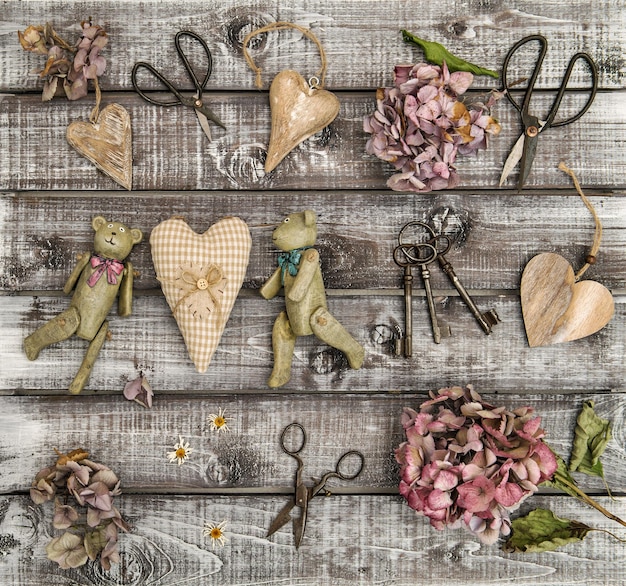 Photo jouets vintage, fleurs d'hortensia et coeurs en bois. mise à plat nostalgique. style rétro nature morte