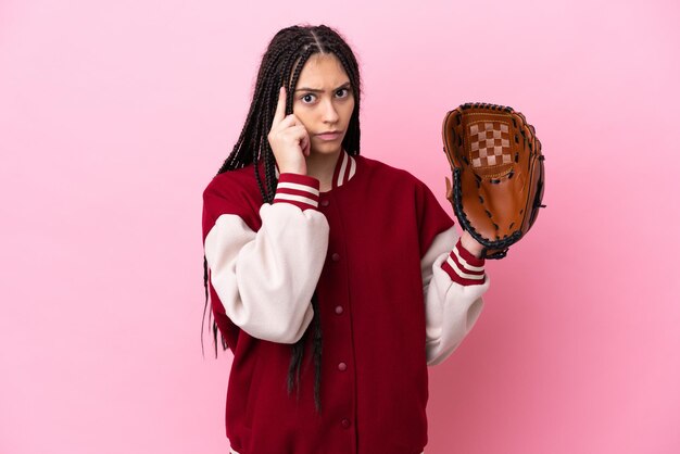 Joueur adolescent avec gant de baseball isolé sur fond rose en pensant à une idée