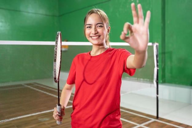 Joueur de badminton de belle fille avec un geste correct tenant une raquette