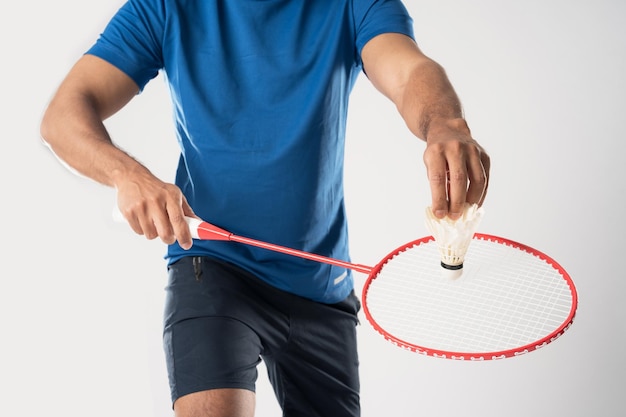 Un joueur de badminton en vêtements de sport tient une raquette et un volant