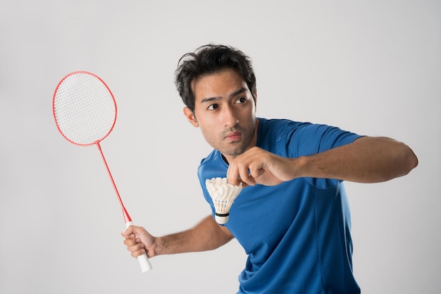 Un joueur de badminton en vêtements de sport tient une raquette et un volant