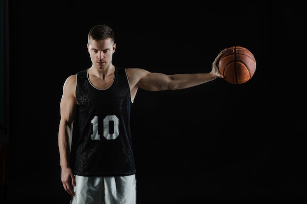 Photo joueur de basket attraper la balle avec sa main gauche