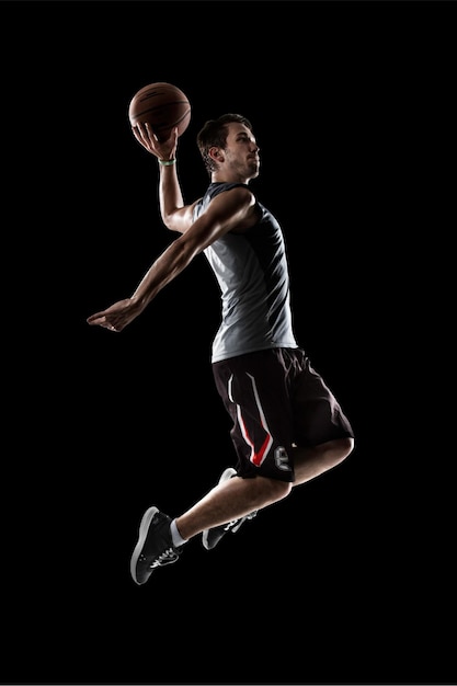 Photo joueur de basket-ball en action fond noir isolé