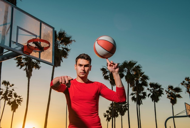 Joueur de basket-ball balle de tir dans cerceau cour extérieure jeu de la jeunesse urbaine hand spinning basket ball bal