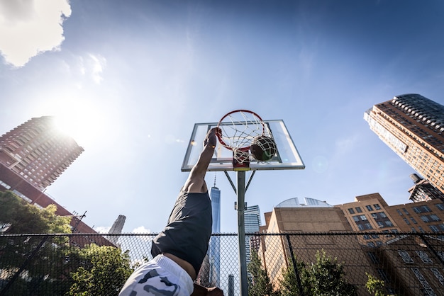 Joueur de basket-ball faisant énorme slam dunk