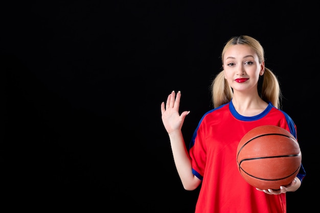 Joueur de basket-ball féminin avec ballon sur fond noir isolé jouer athlète d'action