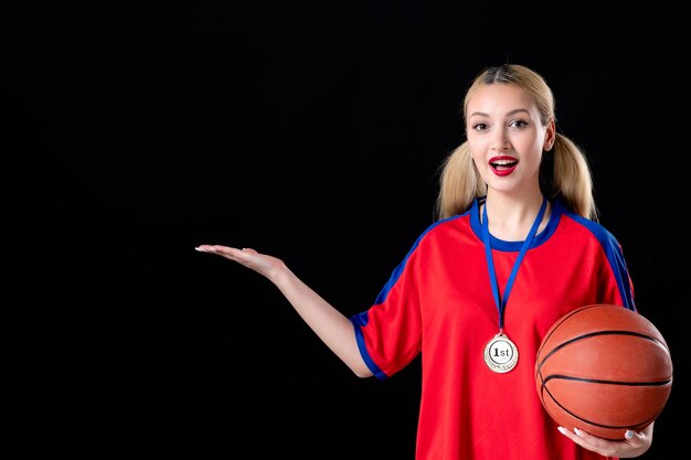 joueur de basket-ball féminin avec ballon et médaille d'or sur fond noir athlète gagnants du trophée