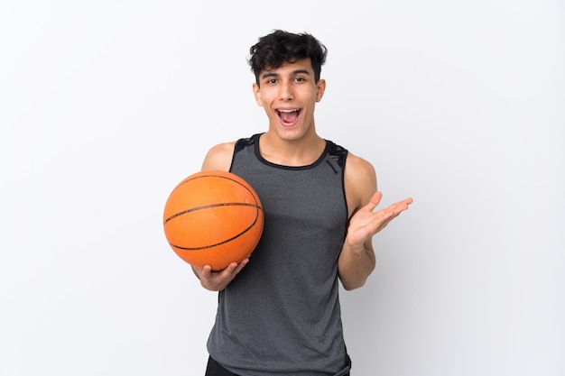 Joueur de basket-ball homme sur mur blanc isolé avec une expression faciale choquée