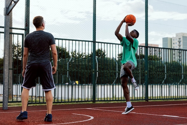 Joueur de basket-ball professionnel avec des amis sur un terrain de basket-ball montrant des amis de formation