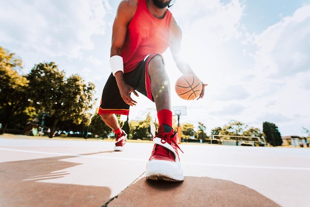 Joueur de basket-ball de rue dribble avec ballon sur le terrain