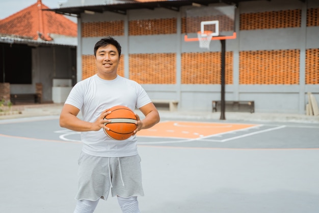 Un joueur de basket-ball tenant un ballon de basket en position debout