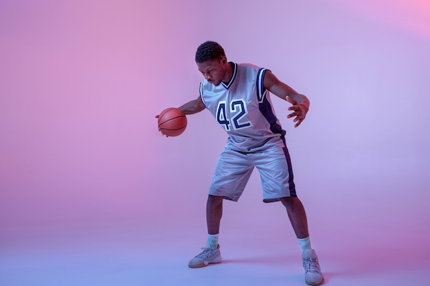 Photo joueur de basket pratiquant avec ballon. baller professionnel en vêtements de sport jouant à un jeu de sport, grand sportif