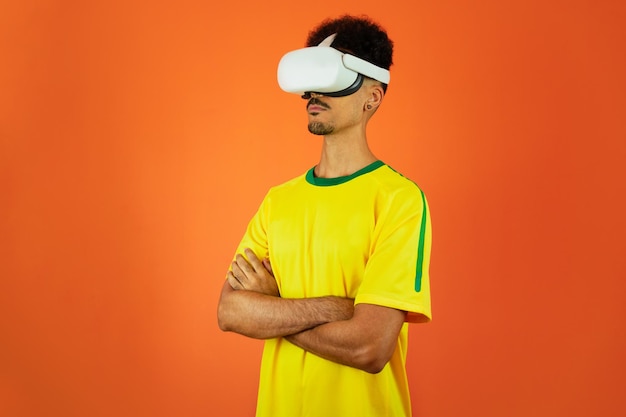 Joueur brésilien Black Man célébrant avec des lunettes virtuelles VR isolé sur fond orange