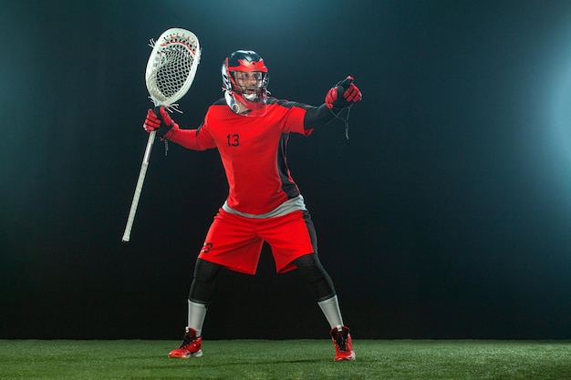 Joueur de crosse athlète sportif en casque rouge sur fond sombre fond d'écran sport et motivation