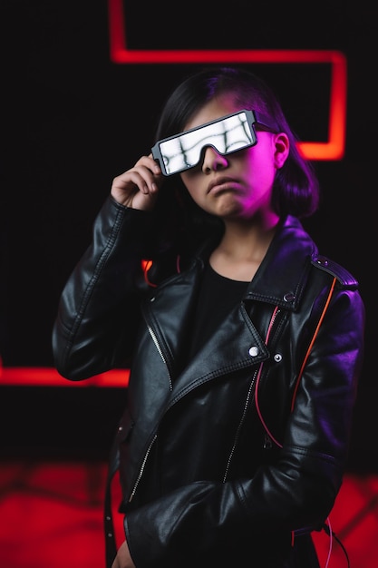 Joueur cyberpunk dans des lunettes futuristes près de l'éclairage au néon rouge, de la réalité virtuelle et du concept de métaverse