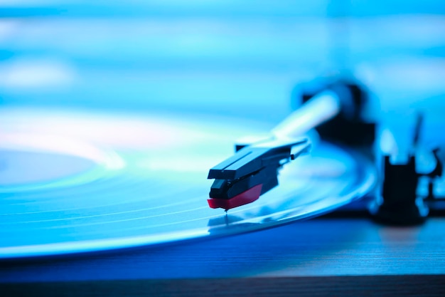 Photo joueur de disques en vinyle avec un disque en arrière-plan lumière du matin de la fenêtre avec des stores