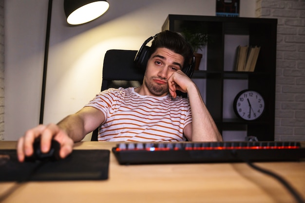 Joueur ennuyé jouant à des jeux vidéo sur ordinateur