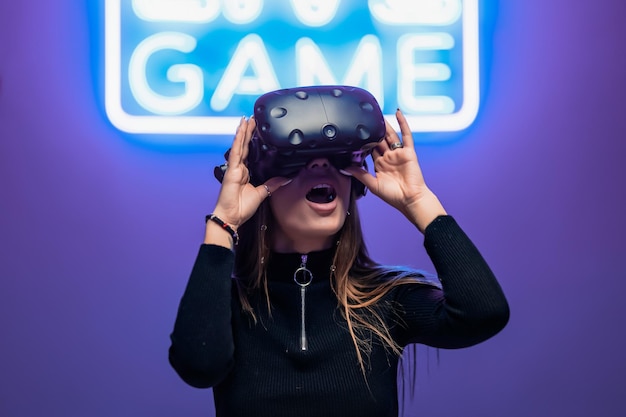 Le joueur est surpris pendant le jeu vr jeu d'enseignes au néon photo de haute qualité