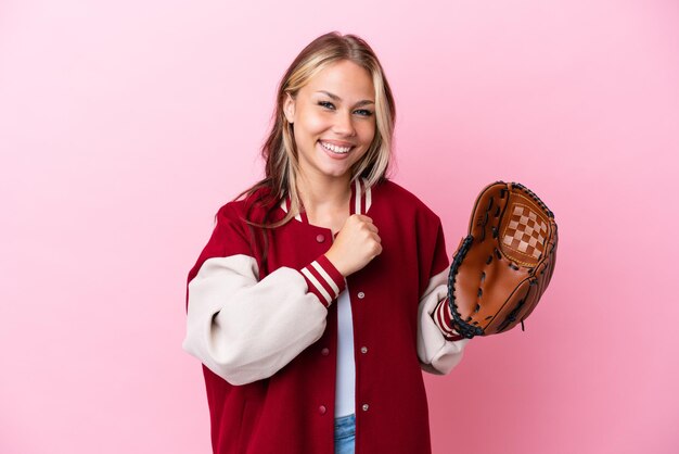 Joueur femme russe avec gant de baseball isolé sur fond rose célébrant une victoire