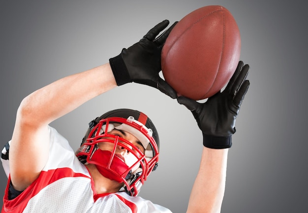 Joueur de football américain avec le ballon sur fond gris