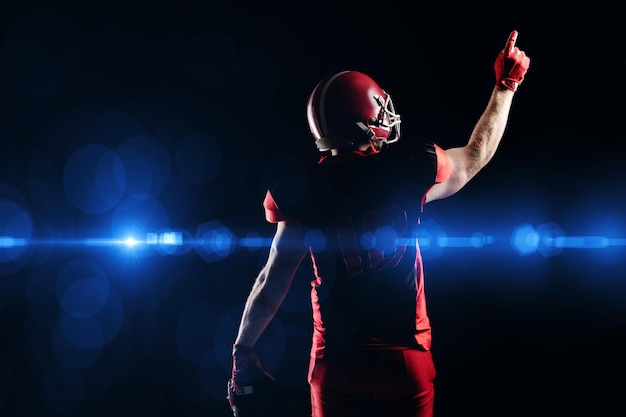 Photo joueur de football américain en casque pointant vers le haut