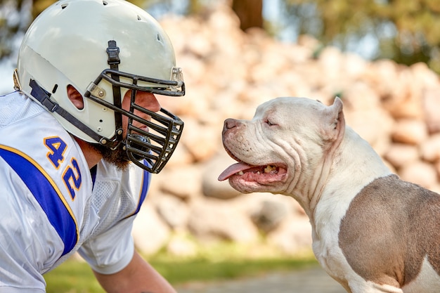 Joueur de football américain avec un chien dans un parc
