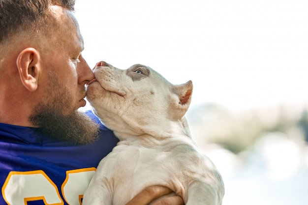 Joueur de football américain avec un chien qui pose en caméra dans un parc.