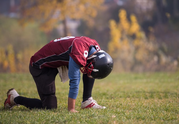 Un joueur de football américain fatigué se reposant après un dur entraînement sur le terrain