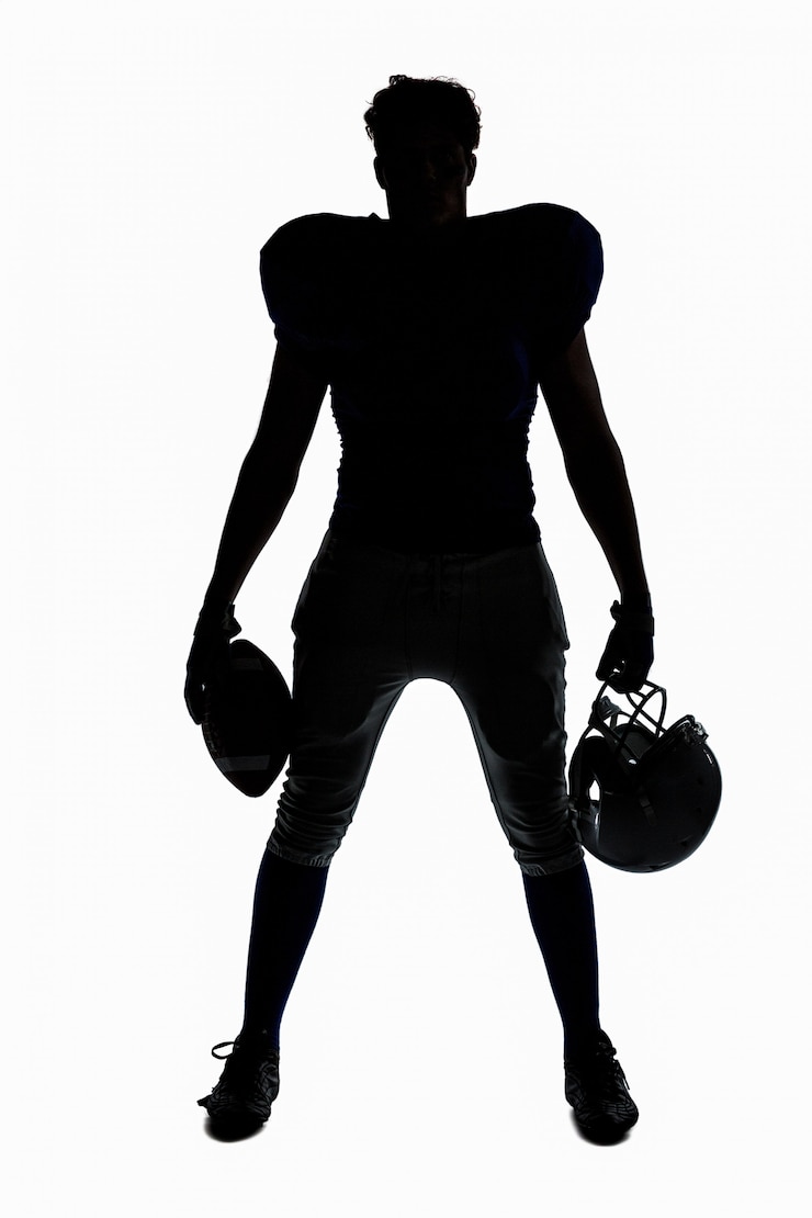 Photo joueur de football américain silhouette tenant le ballon et le casque