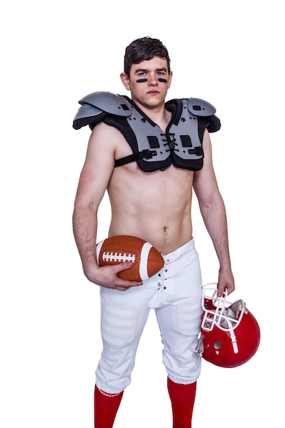 Joueur de football américain tenant une balle et un casque