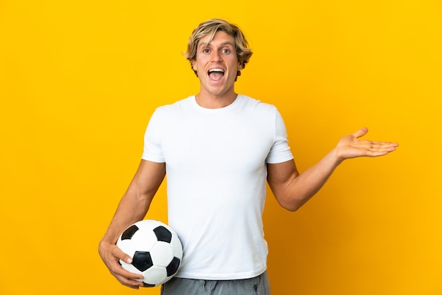 Joueur de football anglais sur mur jaune isolé avec une expression faciale choquée