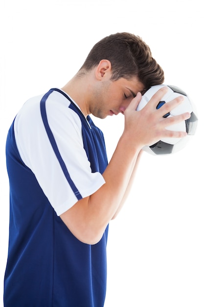 Joueur de football en bleu debout avec le ballon