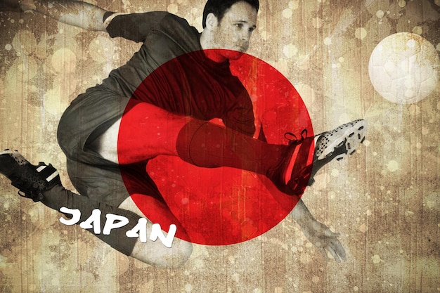 Joueur de football en bleu donnant des coups de pied contre le drapeau du japon en effet grunge