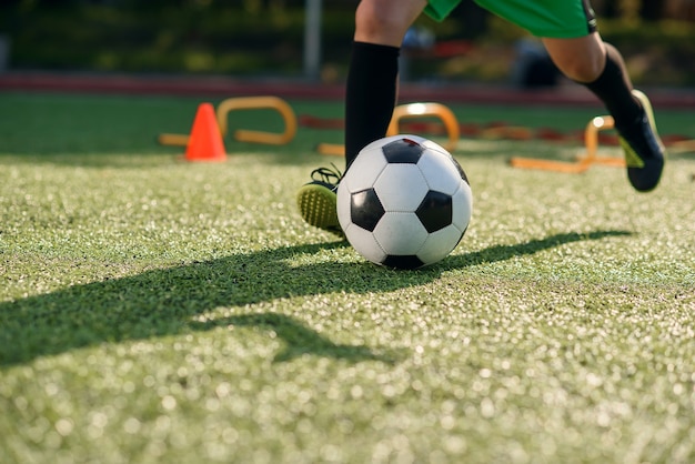 Joueur de football botter le ballon sur le terrain.