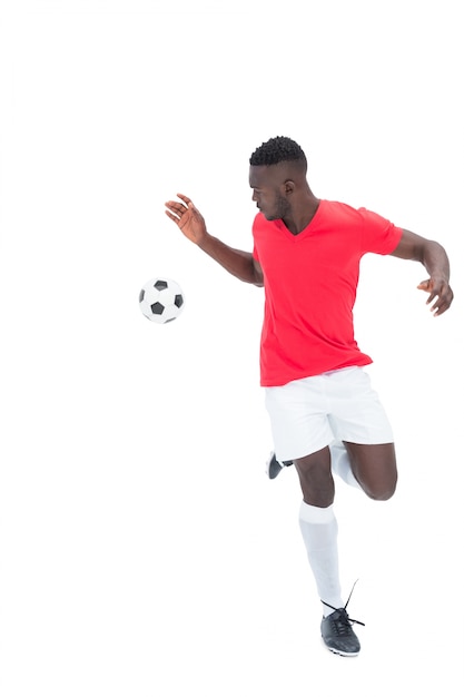 Joueur de football en boule de contrôle de jersey rouge