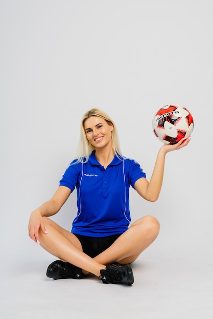 Joueur de football féminin souriant avec ballon isolé sur fond blanc