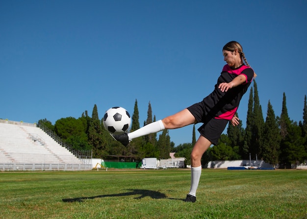 Photo joueur de football femme plein coup sur le terrain