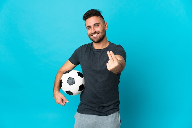 Joueur de football isolé sur fond bleu faisant un geste d'argent