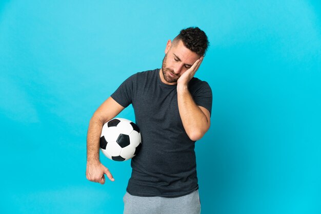 Joueur de football isolé sur fond bleu avec des maux de tête