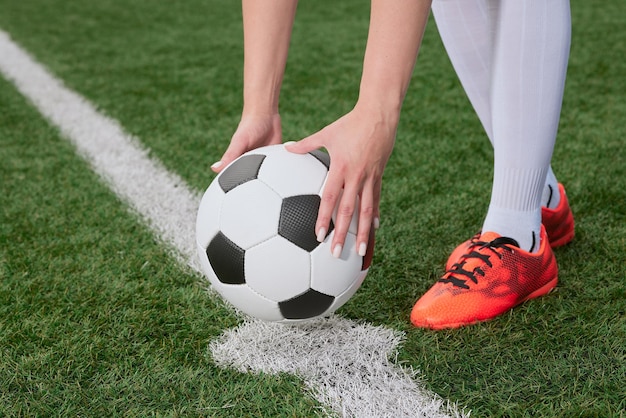 le joueur de football met le ballon sur le terrain de football au début du match de football