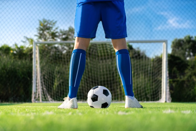 Un joueur de football a placé le ballon de football au point de coup franc avant de tirer un but dans le stade de football